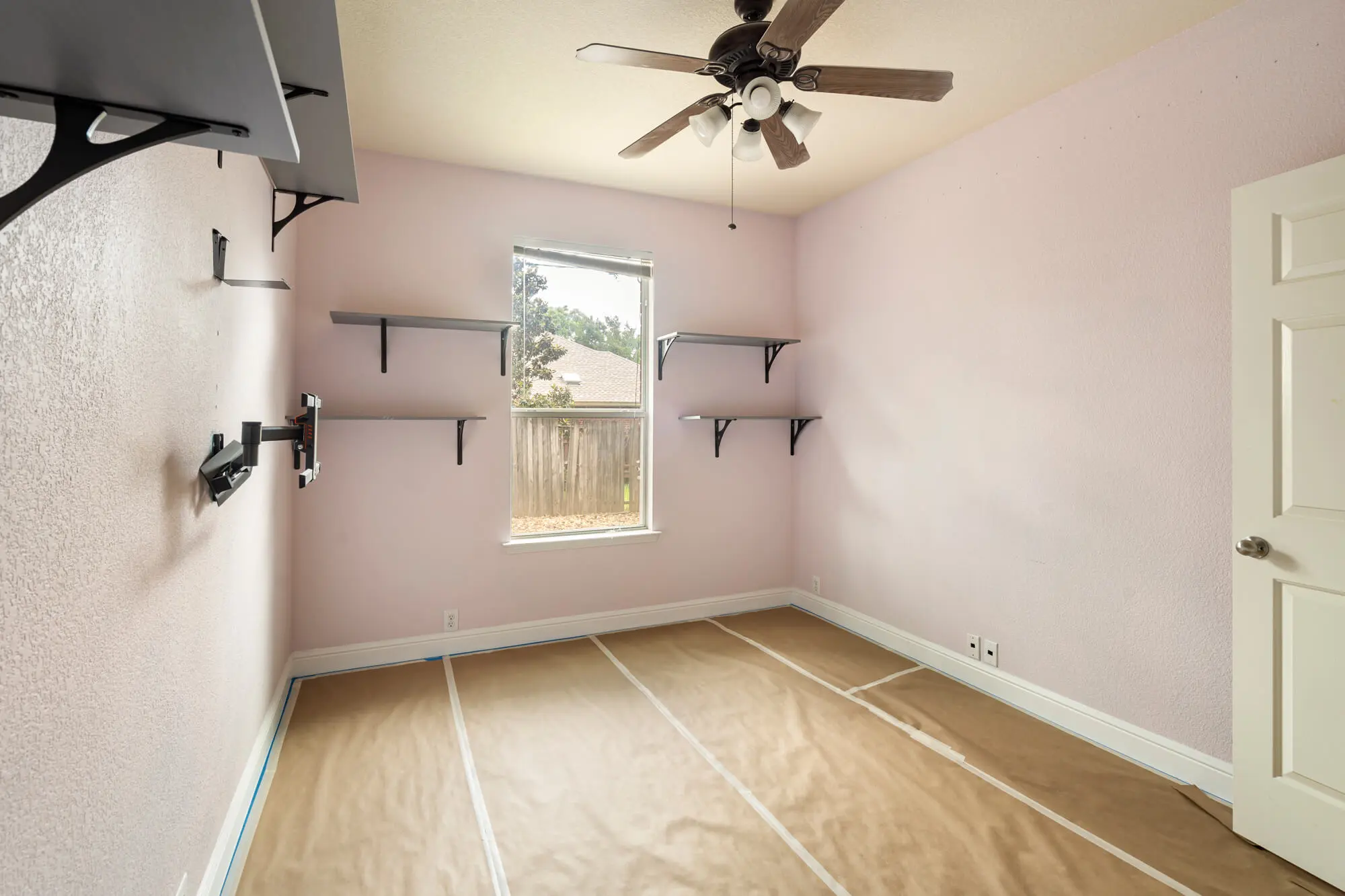 Pink painted bedroom with floor protection and blue tape masking in place during an active interior painting Fort Worth project by J&R Alliance Painting LLC