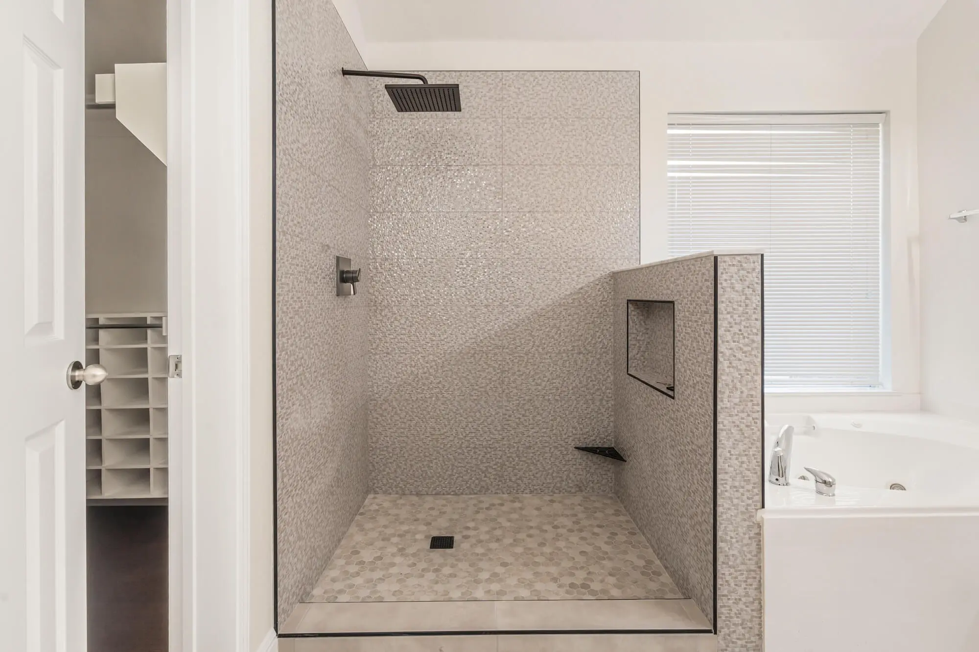 Freshly painted white bathroom walls and trim surrounding a walk-in tile shower with rain head and soaking tub on a DFW interior painting project by J&R Alliance Painting LLC