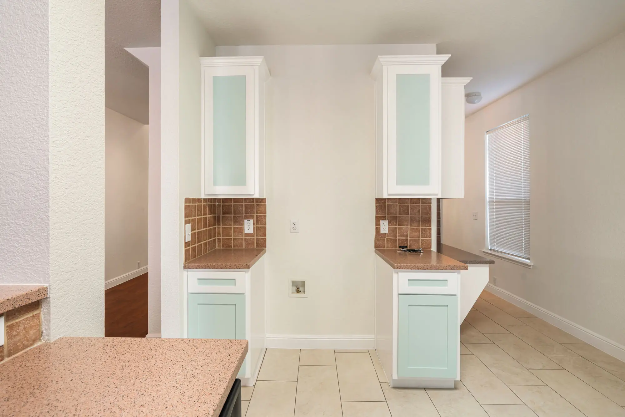 Refinished white upper tower cabinets with frosted glass doors and mint green lower cabinets flanking a kitchen wall on a cabinet refinishing Fort Worth project by J&R Alliance Painting LLC