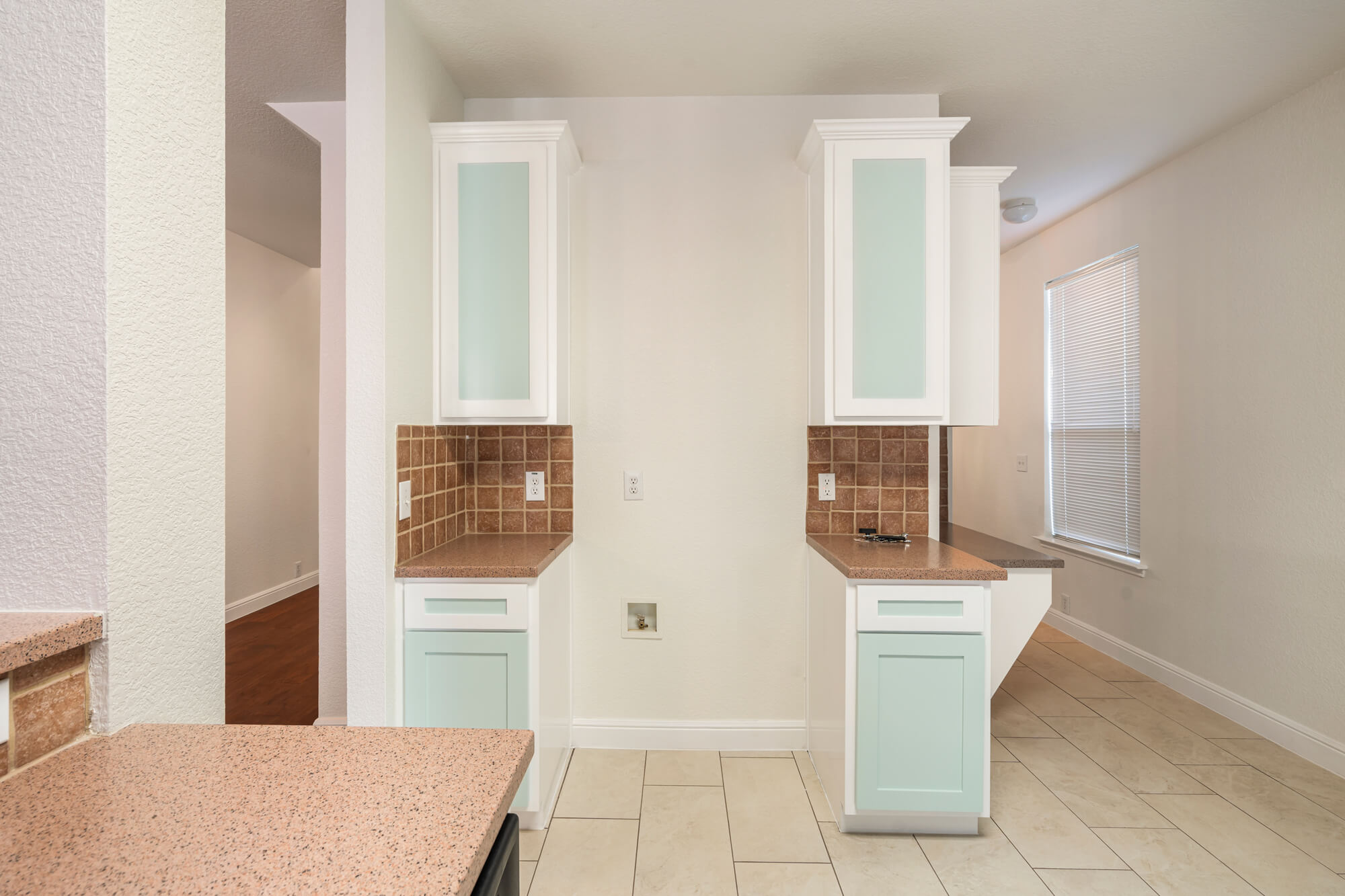 Refinished white upper tower cabinets with frosted glass doors and mint green lower cabinets flanking a kitchen wall on a cabinet refinishing Fort Worth project by J&R Alliance Painting LLC